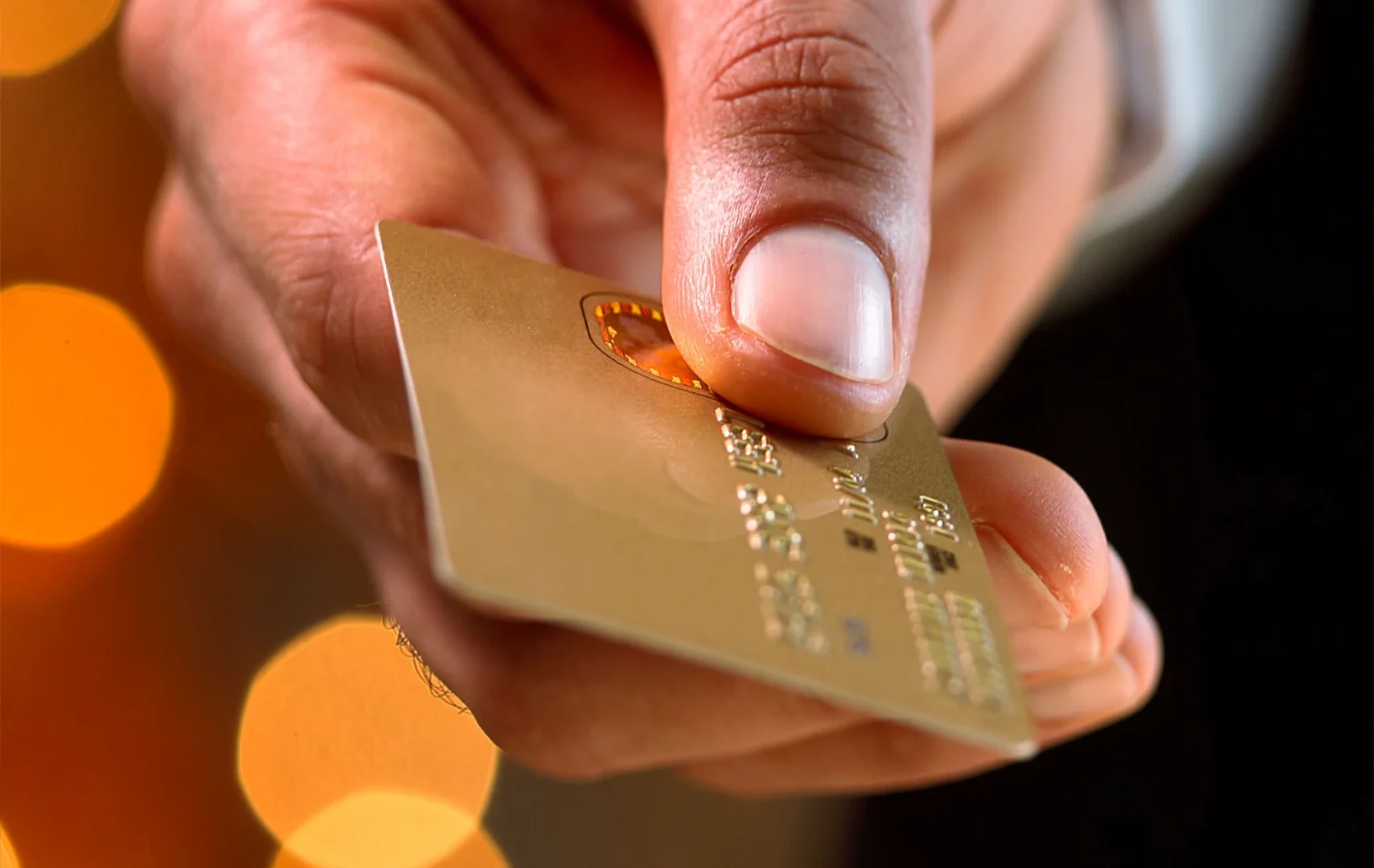 Imagen de un primer plano de la mano de una persona mientras sujeta con sus dedos una tarjeta Golden Visa