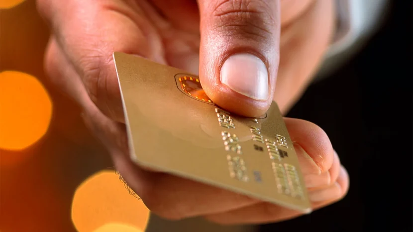 Imagen de un primer plano de la mano de una persona mientras sujeta con sus dedos una tarjeta Golden Visa